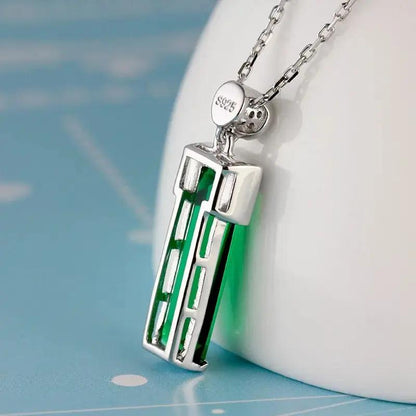 Back side of a Emerald Pendant Necklace with a white and blue background