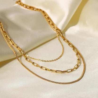 Gold Layered Necklaces on a white fabric background