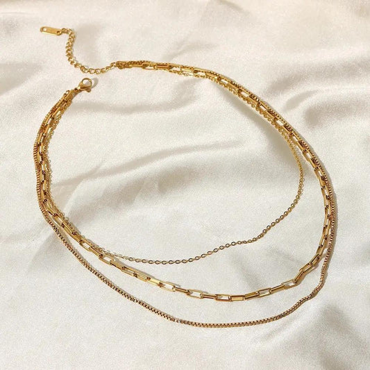 Gold Layered Necklaces on a white satin background