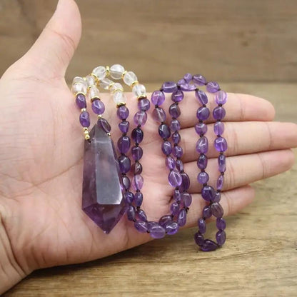 Man holding a Purple Gemstone Necklace in his hand on a beige wooden background