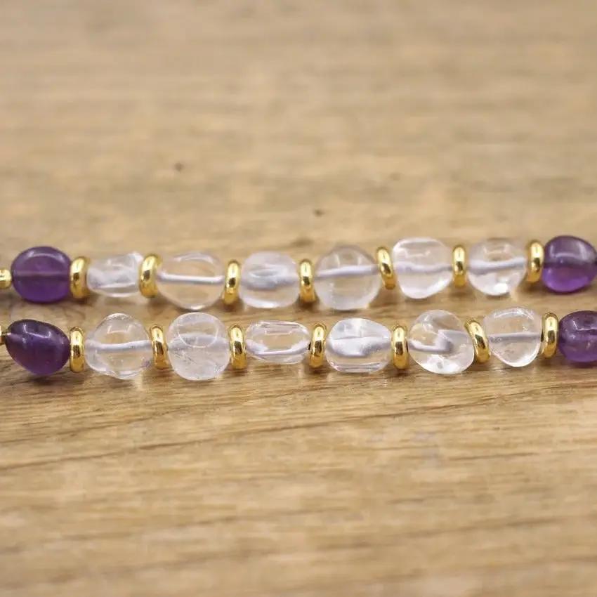 White quartz stones from the Purple Gemstone Necklace on a wooden background